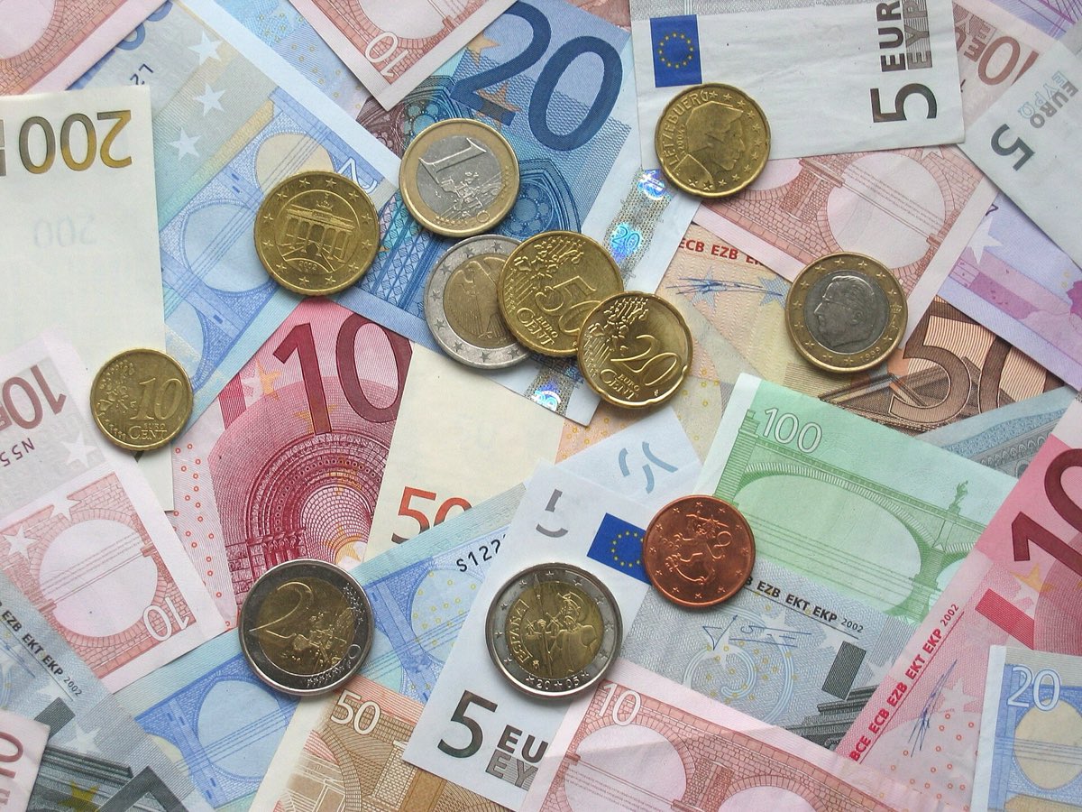 Euro-Banknoten und -Münzen als Symbol für Kosten und Steuern