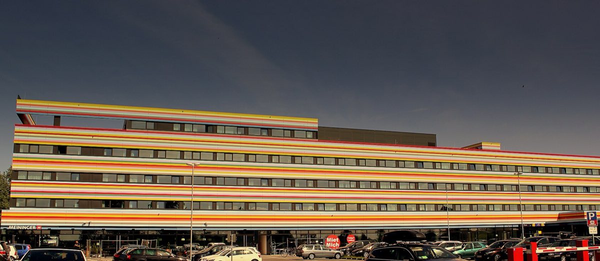 Bunt gestreifte Fassade des MEININGER Hotel Berlin Airport